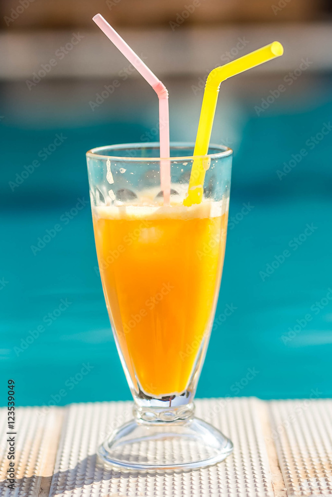 orange juice on the background of the pool orange juice on the background of the pool