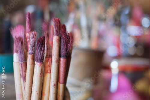 Obraz na plátně bamboo brush with red ink for chinese calligraph at shrine, selective focus with