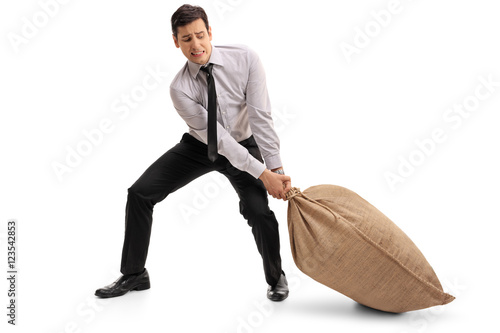 Young businessman pulling a burlap sack photo