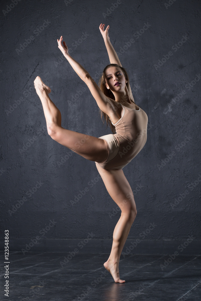 Professional woman dancer posing at wall