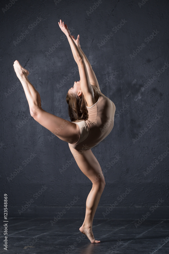 Professional woman dancer posing at wall