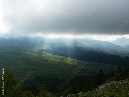 the sun shines through the clouds in the mountains in the valley