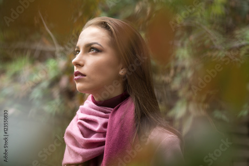 Portrait of young woman in pink topcoat at autumn day