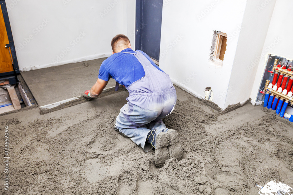 Employee performs sand and cement screed floor. Sand and cement floor screed Employee performs sand and cement screed floor. Sand and cement floor screed