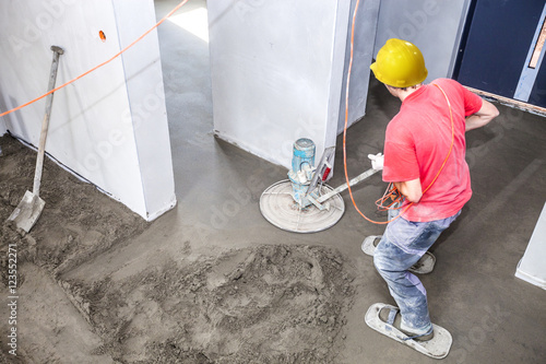 Employee performs sand and cement screed floor. Sand and cement floor screed