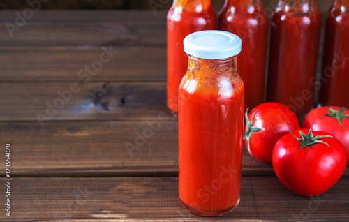 bottles of homemade ketchup and tomatoes. tomato sauce