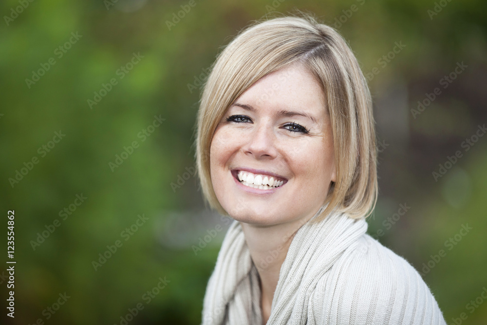 Portrait Of A Blond Woman Smiling At the Camera Outside