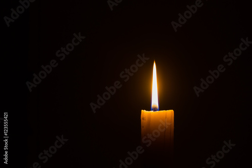 horizontal photo of candle with straight frame on black background with copyspace
