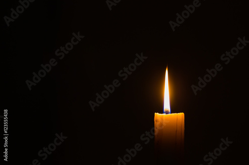 horizontal photo of small candle on dark background with copyspace