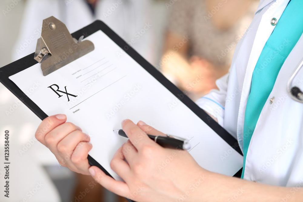 Fototapeta premium Close-up of a female doctor while filling up medical prescription