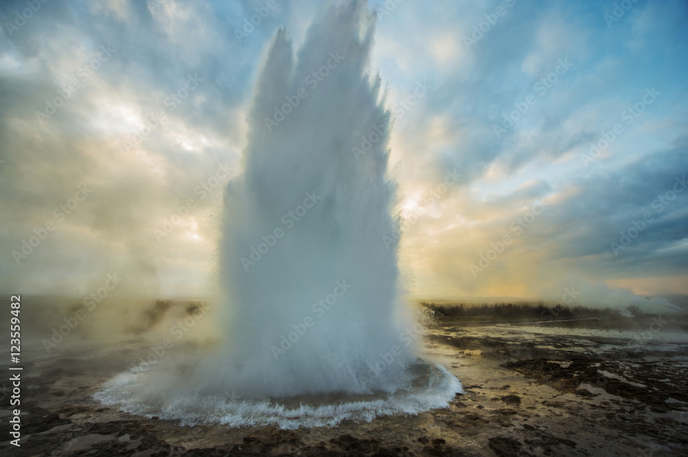 Strokkur geyser erupting against cloudy sky Strokkur geyser erupting against cloudy sky