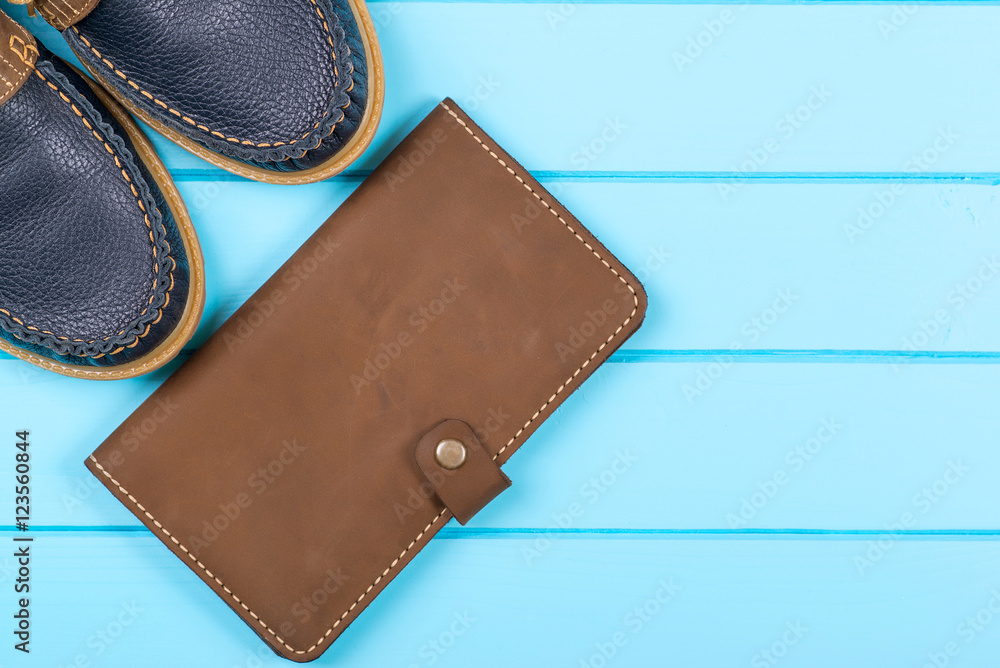 Men's accessories with brown purse and shoes. Top view on wooden background. Men's accessories with brown purse and shoes. Top view on wooden background.