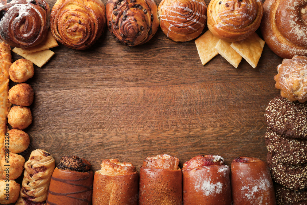 Frame of assorted fresh pastries on wooden background Frame of assorted fresh pastries on wooden background