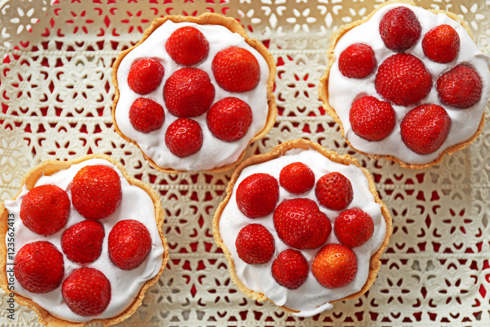 Tasty cakes with strawberries on tray Tasty cakes with strawberries on tray