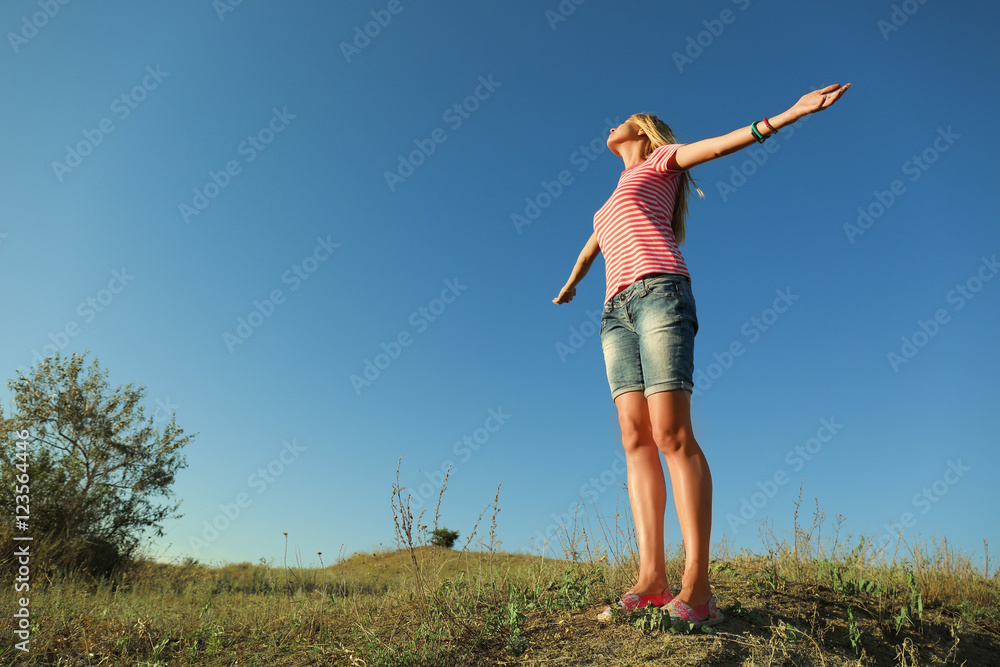 Happy young woman on blue sky background Happy young woman on blue sky background