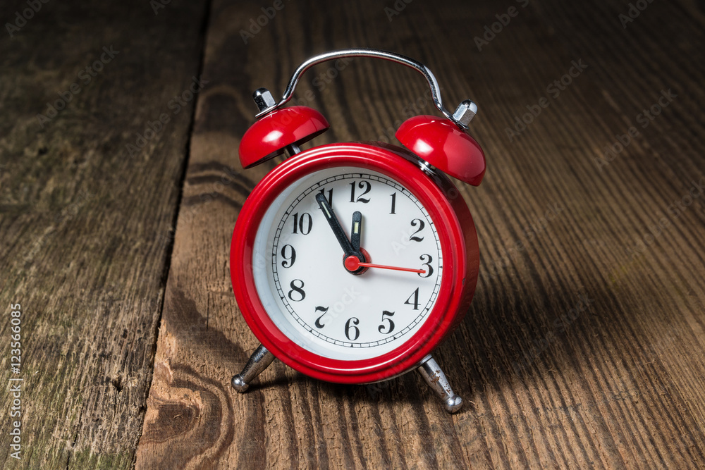 Red alarm clock on the wooden table Red alarm clock on the wooden table