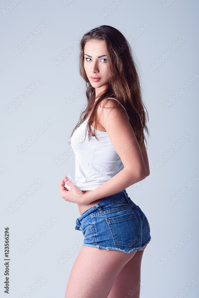 Fashion shot: cute young girl in denim shorts and shirt Stock Photo | Adobe  Stock