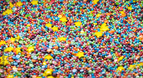 Sweet colorful confectionery sprinkling texture with yellow stars- sugar sprinkle dots, decoration for cake and bakery