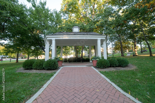 White gazebo in park surrounded by plants and flowers