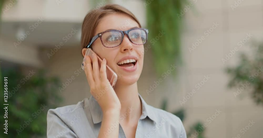 young and attractive business woman talking on the phone walking along the bank young and attractive business woman talking on the phone walking along the bank