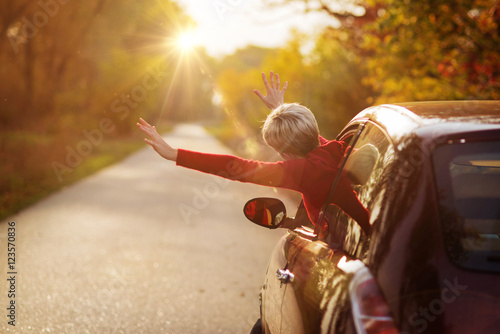 Freedom car travel concept - woman relaxing out of window in a c
