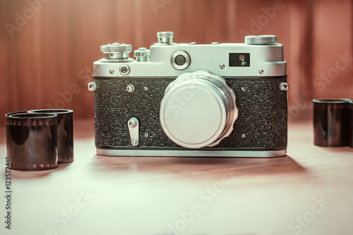 Vintage film camera with films on wooden background