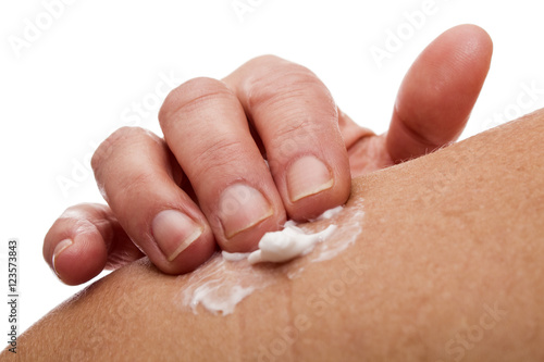 senior woman rubbing her shoulder with a white pain relieving cr photo