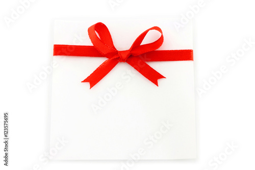 Sheet with red holiday bow on white background