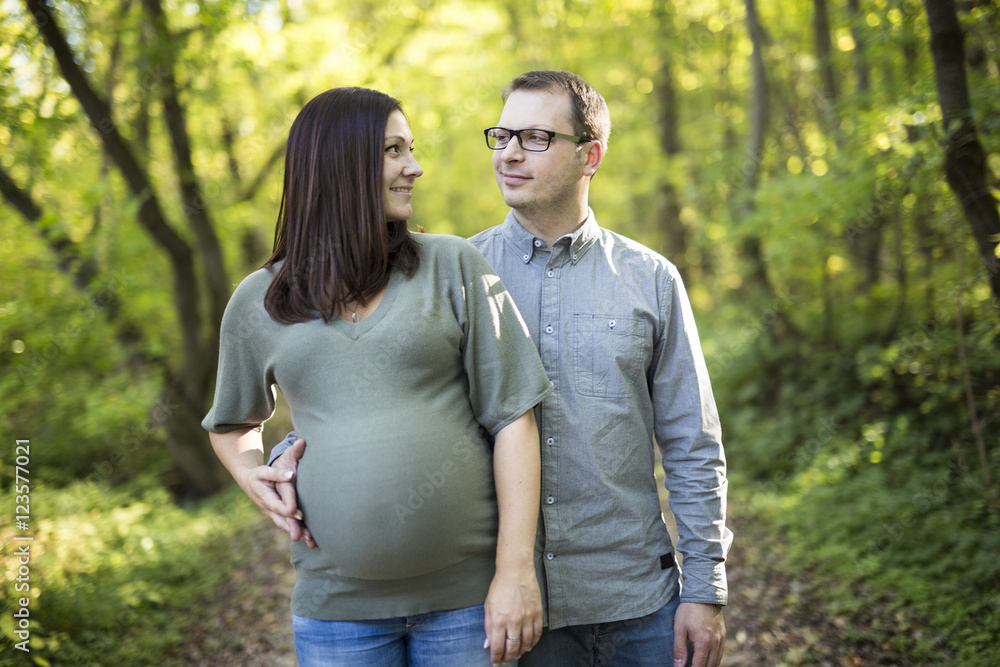 Beautiful pregnant couple relaxing outside in the park. Beautiful pregnant couple relaxing outside in the park.