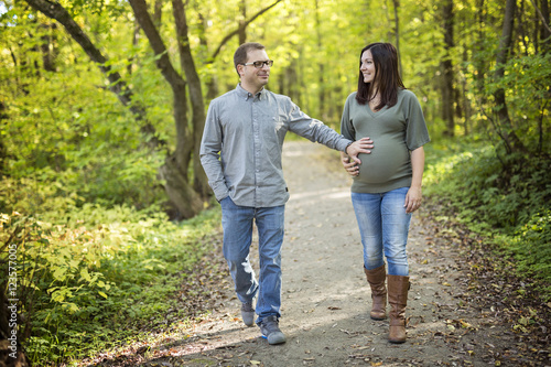 Beautiful pregnant couple relaxing outside in the park. © Louis-Photo