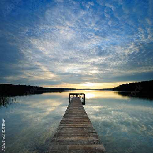 Long Wooden Pier into a Calm Lake at Sunrise