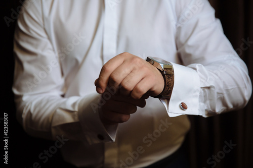 Businessman checking time on his wristwatch. men's hand with a watch. © romannoru