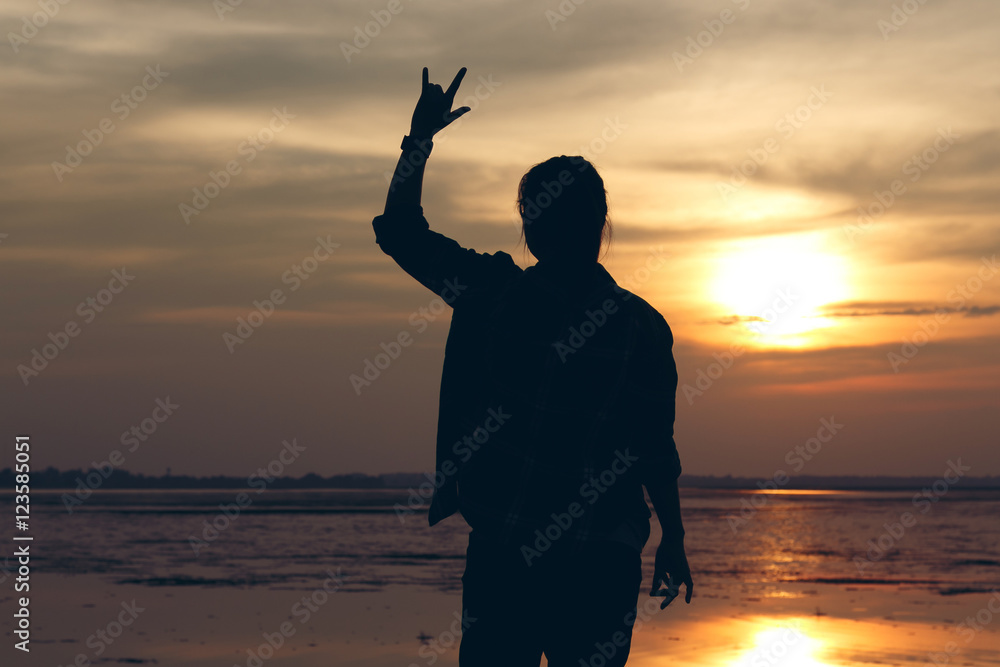 Silhouette woman lifestyle relax at sunset and her raise hands t