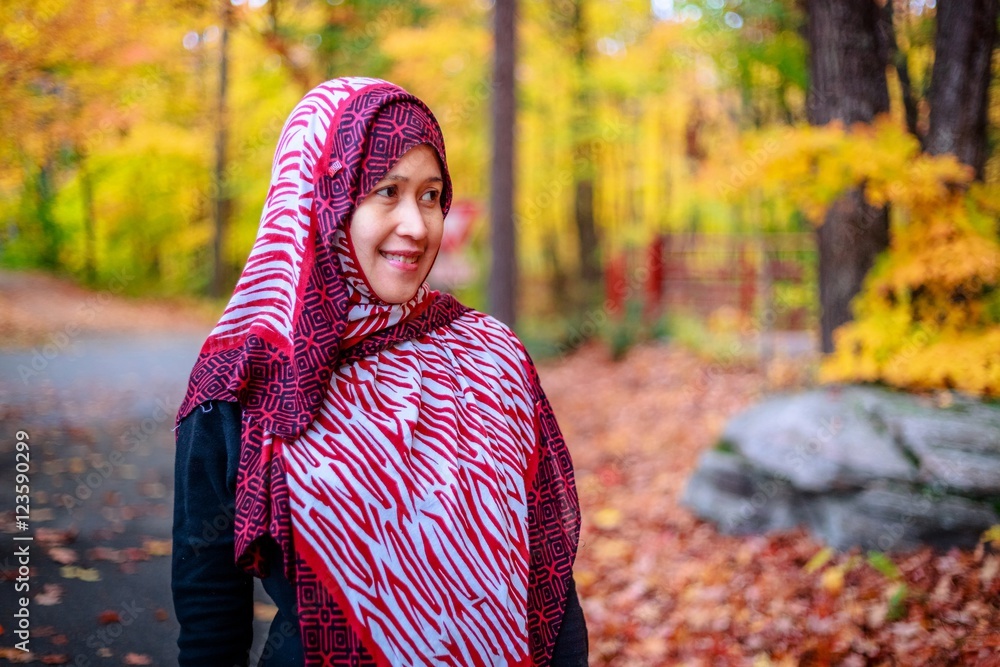 Muslim woman in Canada during autumn with colorful maple leaf as background Muslim woman in Canada during autumn with colorful maple leaf as background
