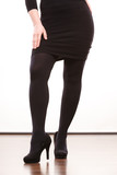 Female legs in black pantyhose heeled shoes