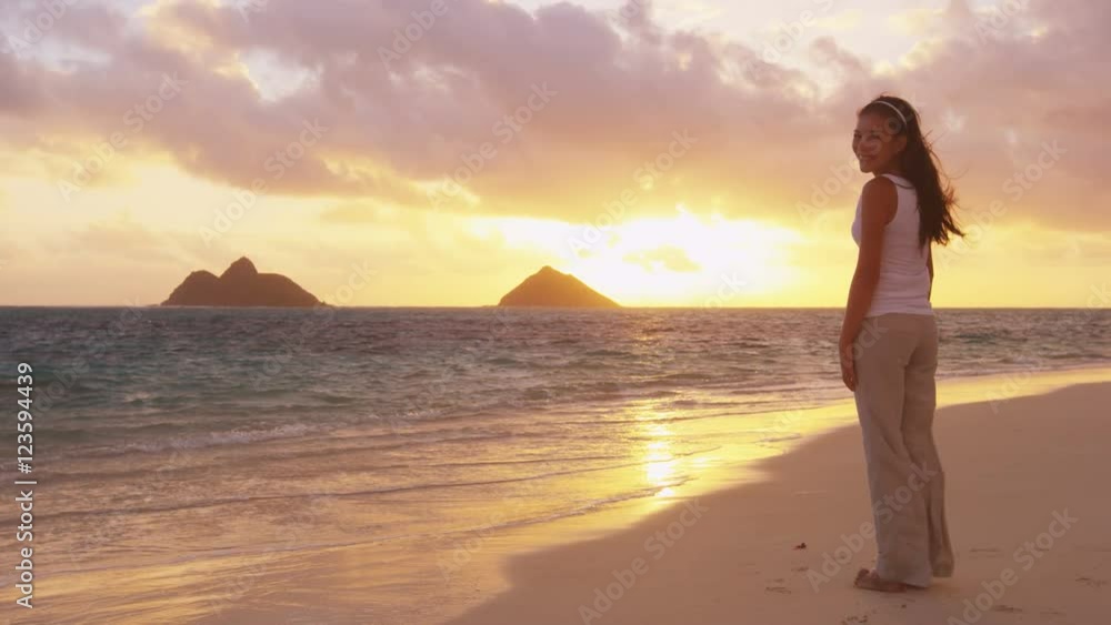 Girl looking at camera at sunrise beach before yoga on Lanikai, Oahu, Hawaii. Mixed race Asian Caucasian women smiling happy enjoying beautiful pristine beach. Girl looking at camera at sunrise beach before yoga on Lanikai, Oahu, Hawaii. Mixed race Asian Caucasian women smiling happy enjoying beautiful pristine beach.
