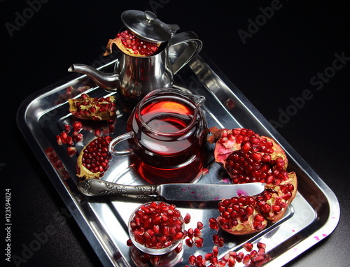 гранат и гранатовый сок на металлическом блюде с чайником