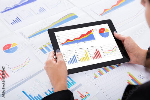 Businesswoman Analyzing Financial Graphs Using Digital Tablet