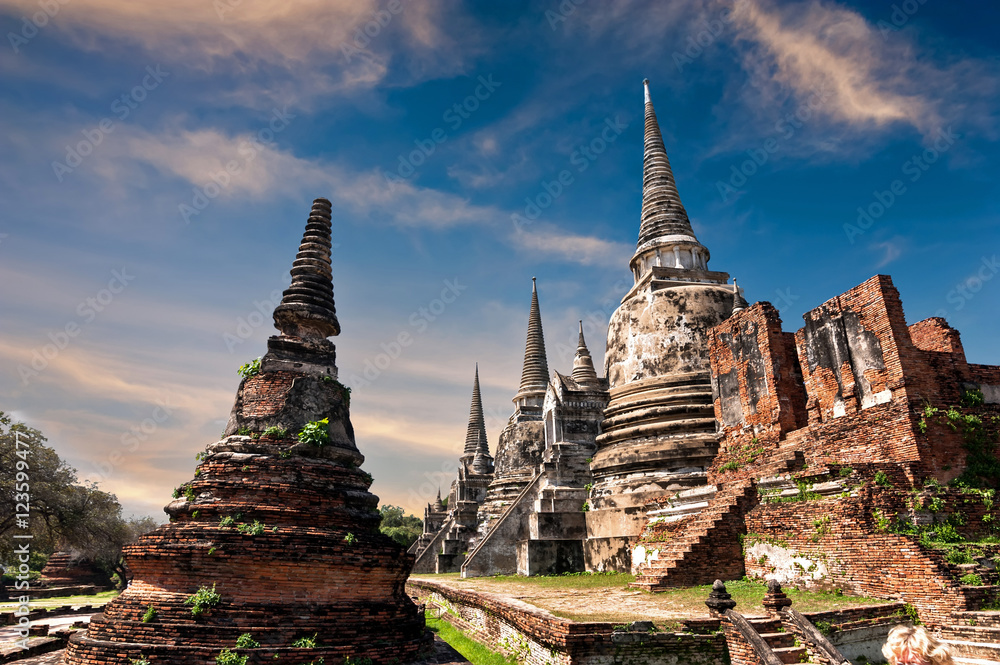Fototapeta premium Asian religious architecture. Ancient Buddhist pagoda ruins at Wat Phra Sri Sanphet temple under sunset sky. Ayutthaya, Thailand travel landscape and destinations