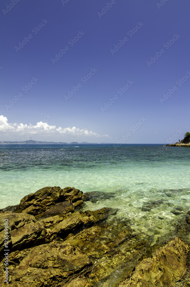 tropical island with clear sea water and blue sky background at sunny day