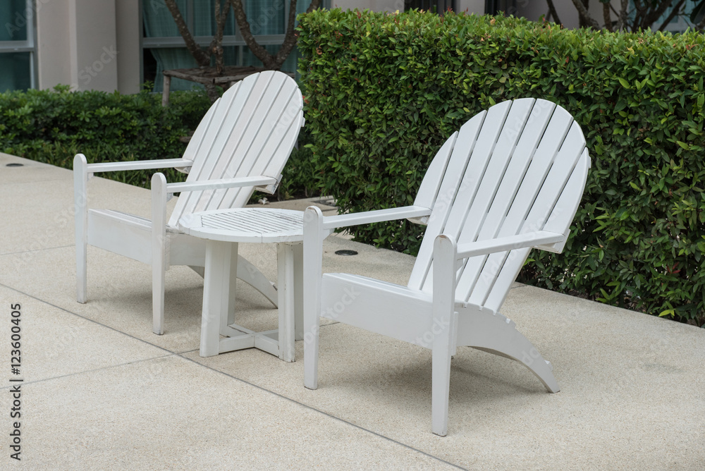 plastic chair on swimming pool side with garden in outdoor design. Image of white plastic chairs by the swimming pool use for background