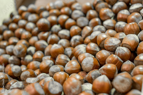 Chestnuts background, Chestnuts roasting. Many fresh tasty ripe sweet chestnut brown husks fruit edible seeds nuts full of vitamin for healthy eating for sale. Selective focus blurred background
