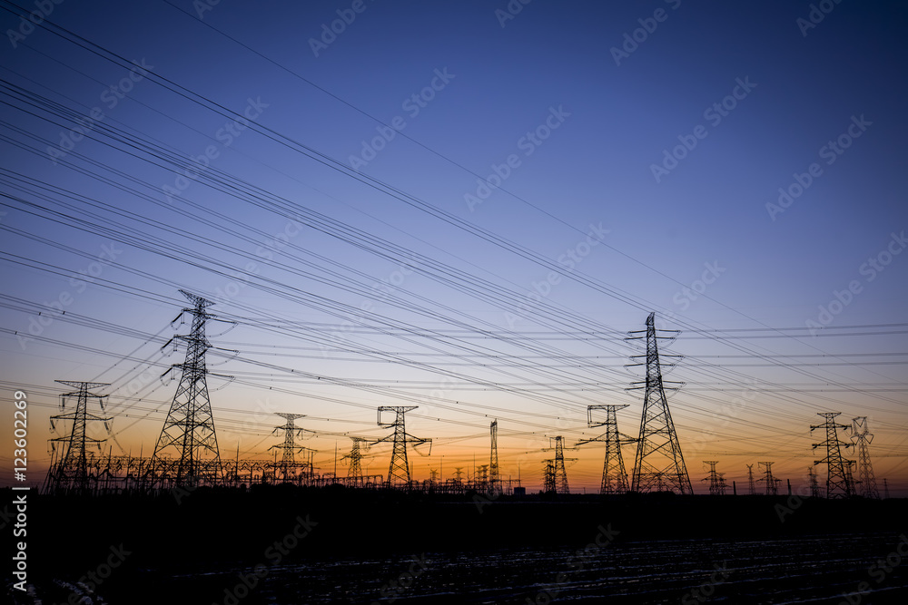 The silhouette of the evening electricity transmission pylon
