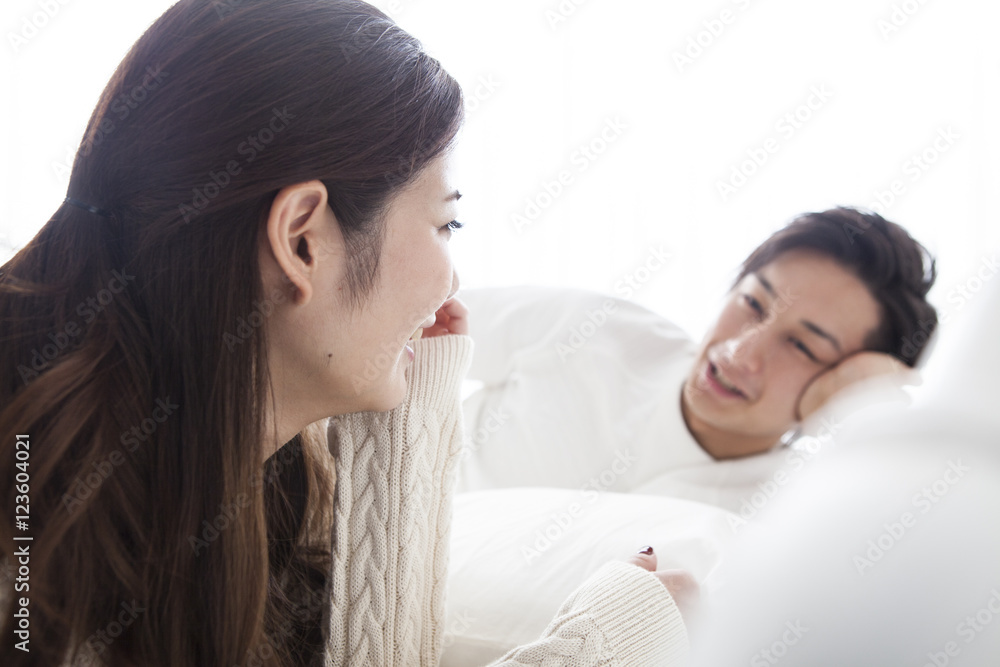 Young couple are talking happily in on the bed