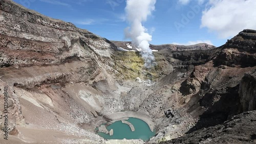 Volcanic landscape of Kamchatka: view of crater active Gorely Volcano, crater lake and fumarolic activity of volcano - active fumaroles, emissions steam and gas. Russia, Far East, Kamchatka Peninsula.