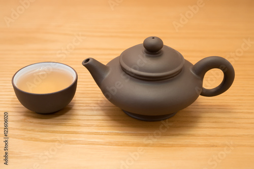 side view cup of tea and teapot on wood table