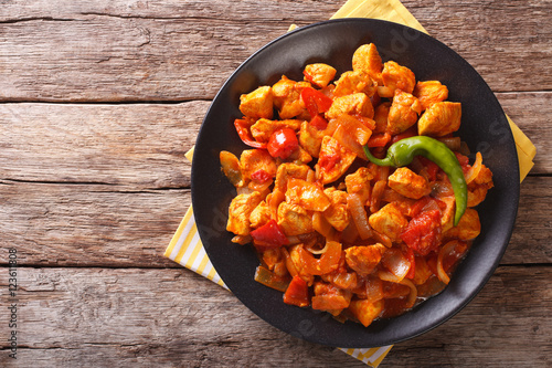 Spicy chicken jalfrezi with pepper and onion close-up. horizontal top view
