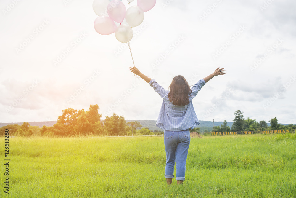 © sunti - Back of happy beautiful young woman standing holding colorful of