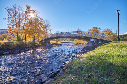 across the river bridge in the autumn park