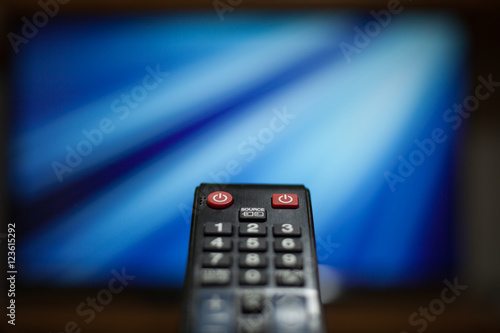 TV (television) remote in front of the TV (color toned image)